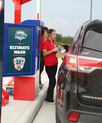 Clean Wash team members greeting a customer at the pay station